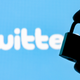 Fingers hold a closed security lock on the background of the Twitter social network logo.
